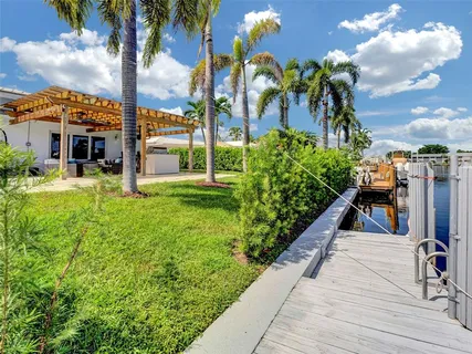 a view of a house with a yard and potted plants