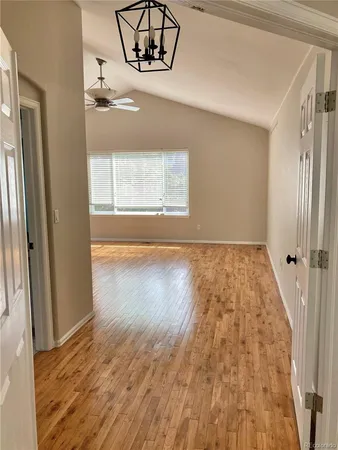 a view of empty room with wooden floor and window