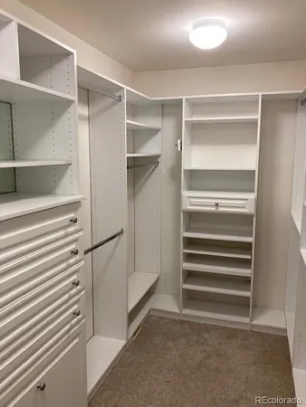 a view of walk in closet with empty racks