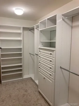 a view of walk in closet with empty racks