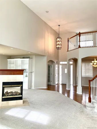 a view of a hallway with a fireplace and chandelier