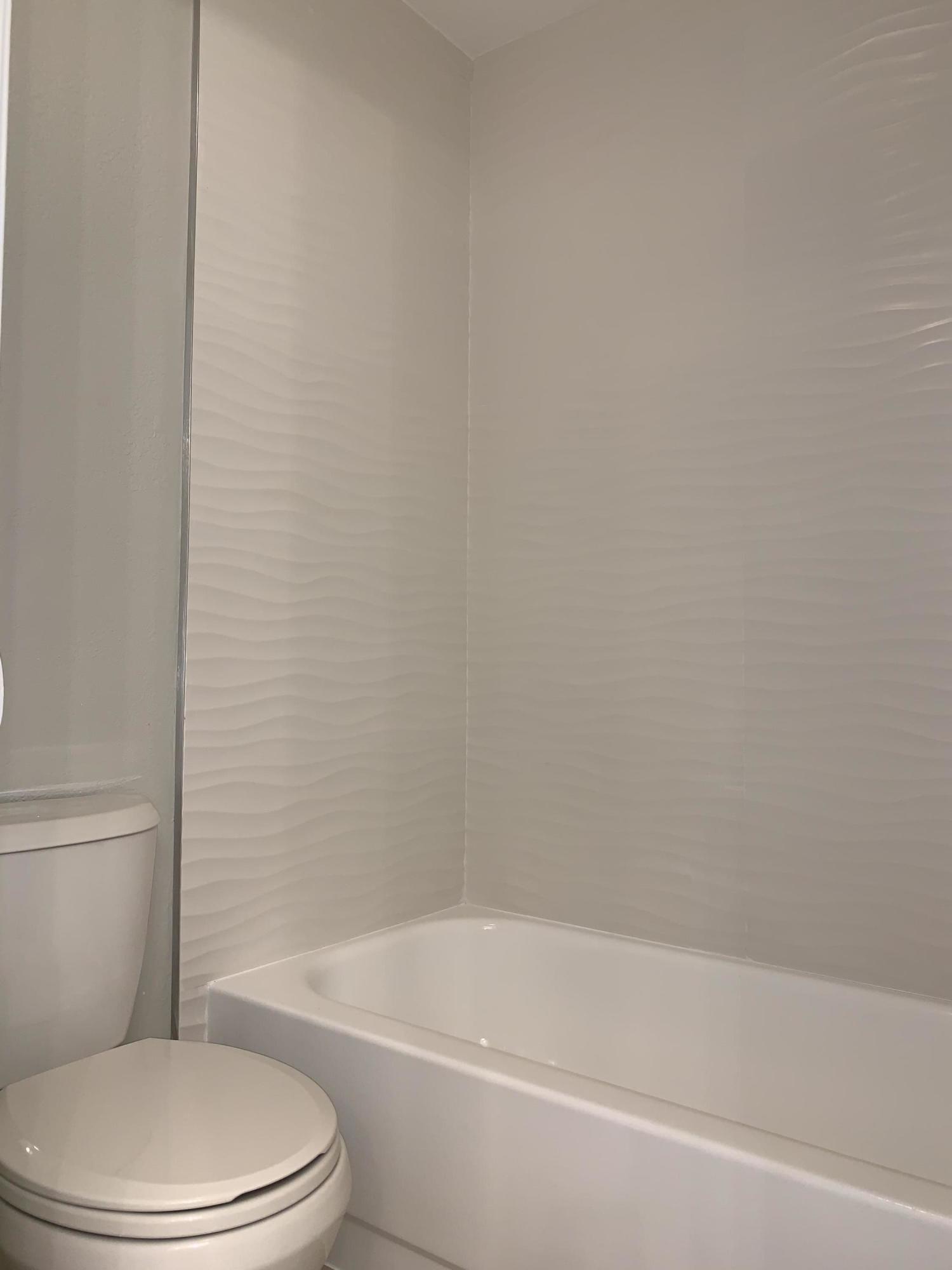 320 Southeast 2nd Avenue, Unit B1 Deerfield Beach, FL 33441 - Photo 11 of 22 a white toilet and tub sitting next to a white cabinet