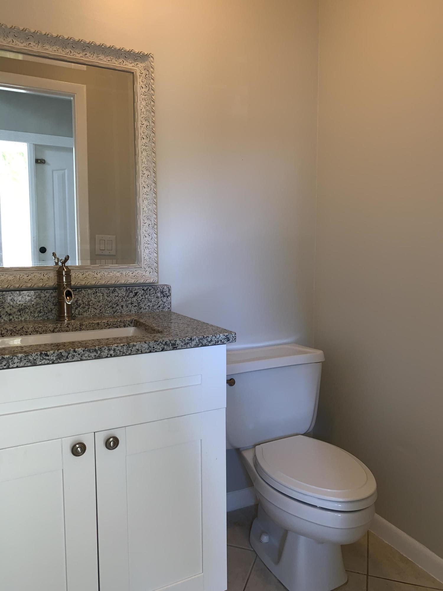320 Southeast 2nd Avenue, Unit B1 Deerfield Beach, FL 33441 - Photo 13 of 22 a bathroom with a granite countertop toilet and a sink