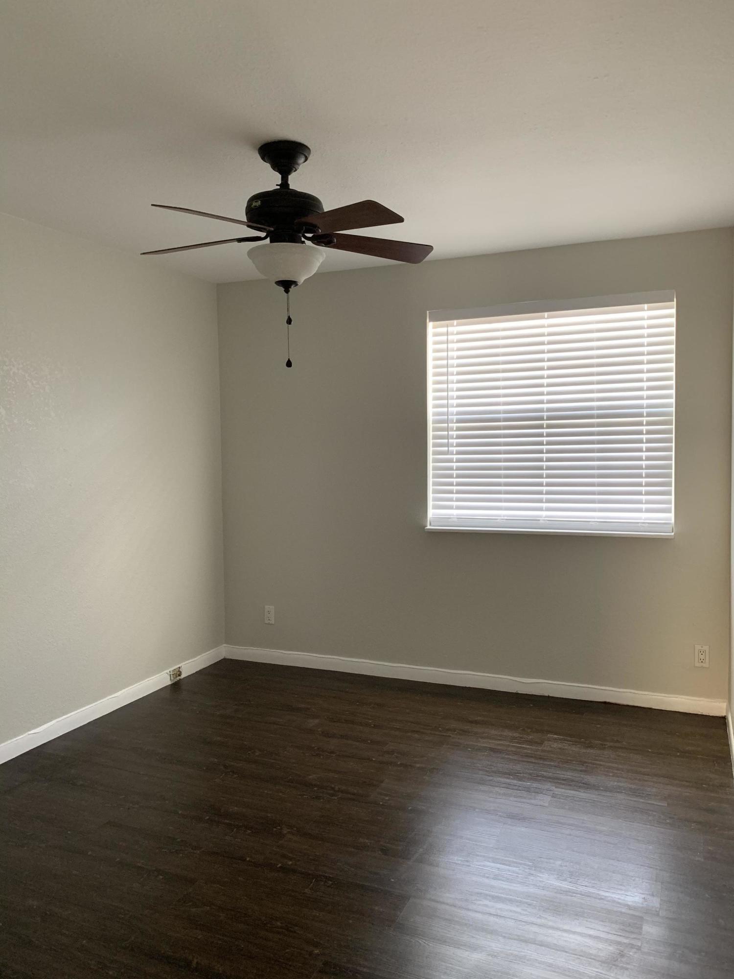 320 Southeast 2nd Avenue, Unit B1 Deerfield Beach, FL 33441 - Photo 18 of 22 a view of an empty room with wooden floor and a window