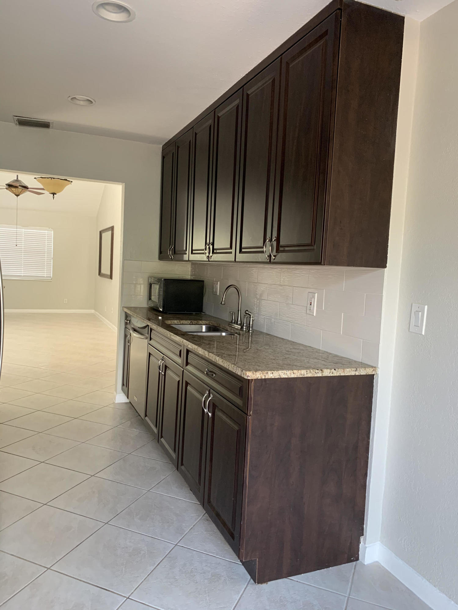 320 Southeast 2nd Avenue, Unit B1 Deerfield Beach, FL 33441 - Photo 4 of 22 a kitchen with granite countertop a sink and cabinets