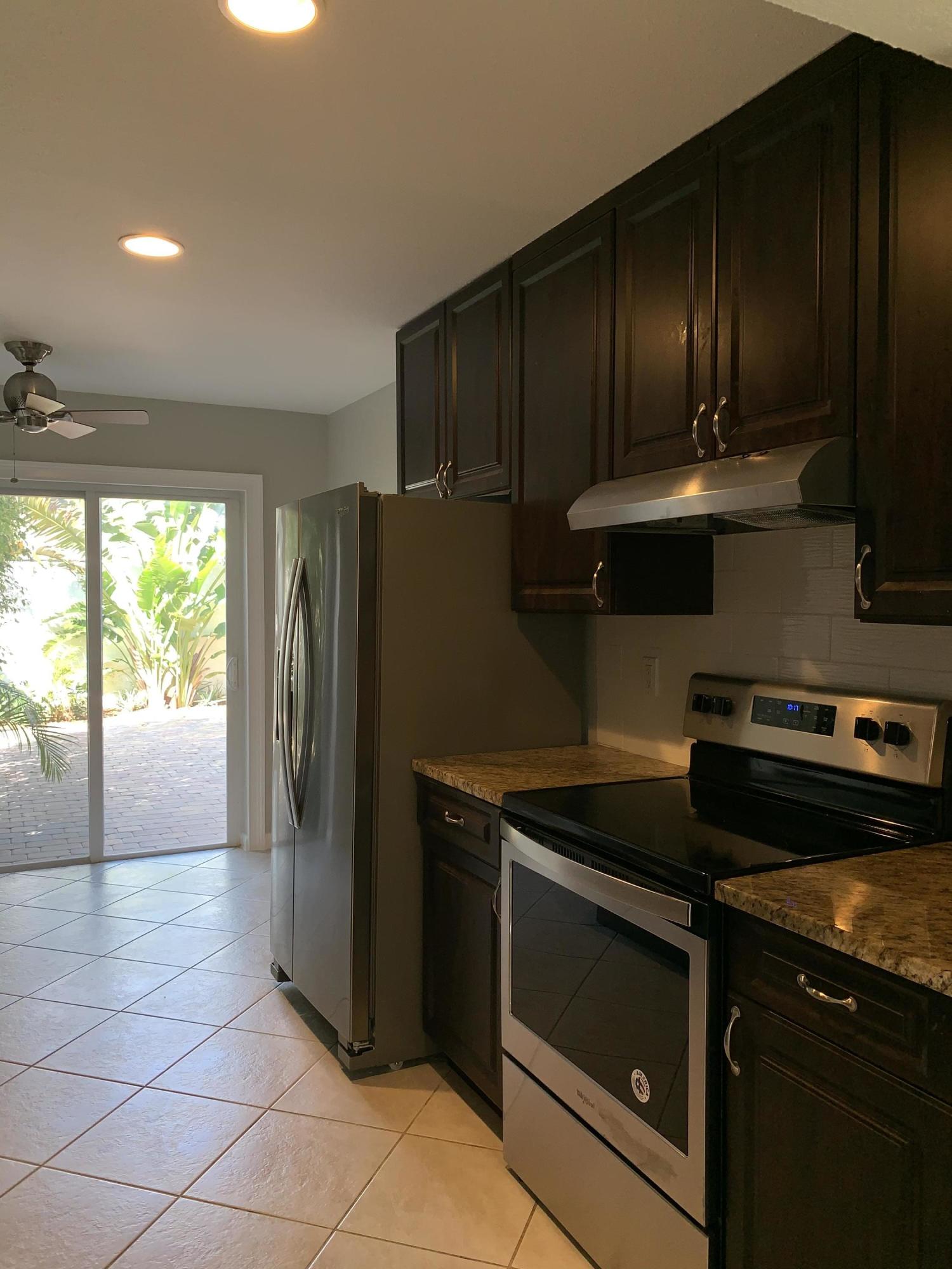 320 Southeast 2nd Avenue, Unit B1 Deerfield Beach, FL 33441 - Photo 6 of 22 a kitchen with a refrigerator stove and cabinets