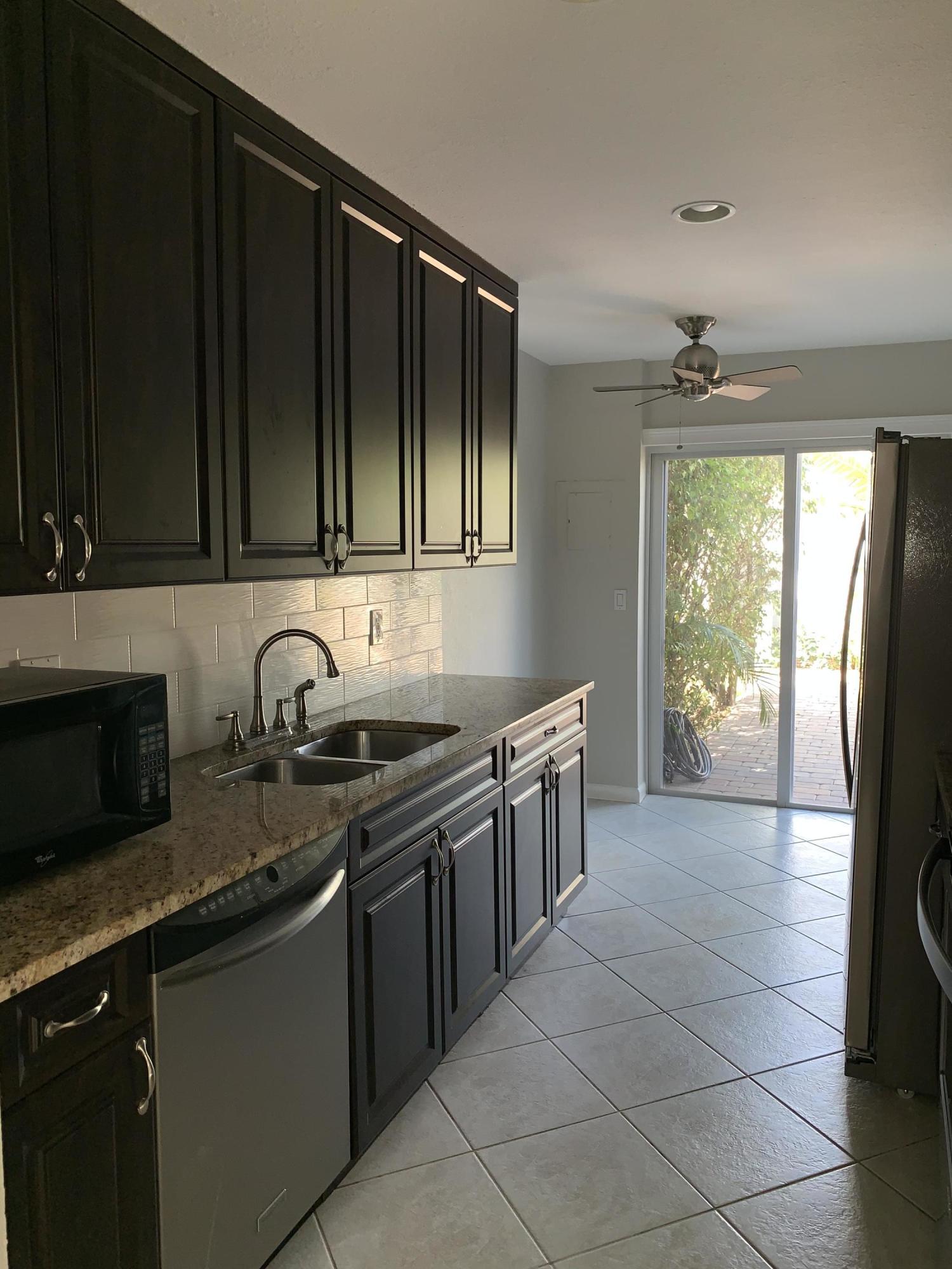 320 Southeast 2nd Avenue, Unit B1 Deerfield Beach, FL 33441 - Photo 7 of 22 a kitchen with stainless steel appliances granite countertop a stove a sink and a microwave