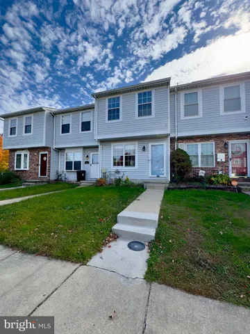 a front view of a house with a garden and trees
