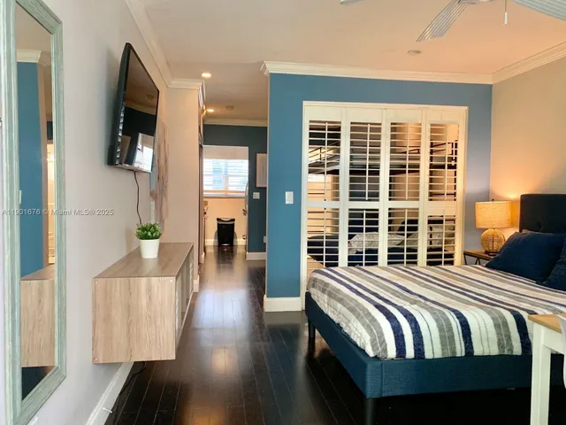 a bedroom with bed and wooden floor