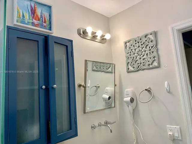 a bathroom with a painting on the wall and shower