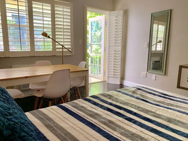 a bedroom with a bed window and a table