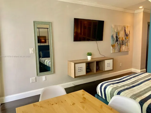 a bedroom with furniture and a flat screen tv