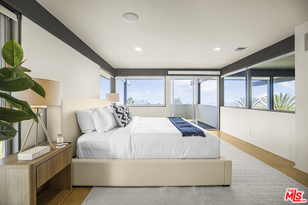 9892 Beverly Grove Drive Beverly Hills, CA 90210 - Photo 19 of 39 a living room with a bed furniture and a large window
