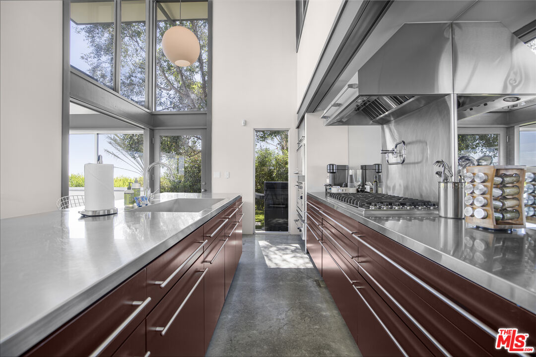9892 Beverly Grove Drive Beverly Hills, CA 90210 - Photo 2 of 39 a large kitchen with kitchen island white cabinets and stainless steel appliances