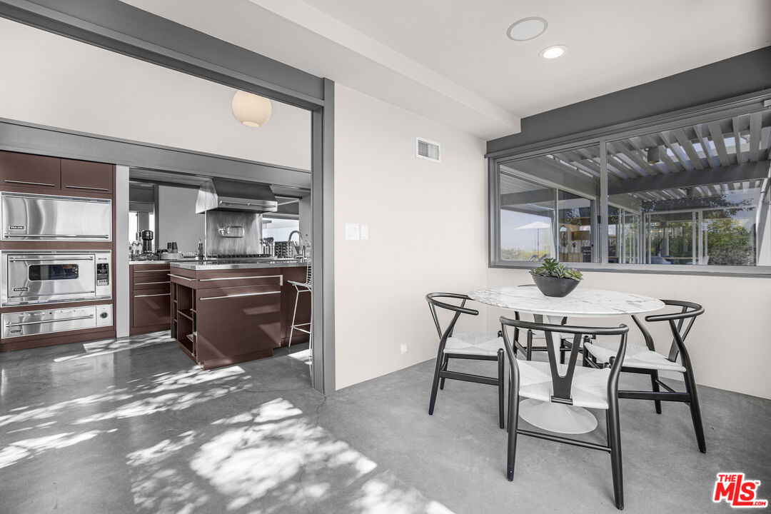 9892 Beverly Grove Drive Beverly Hills, CA 90210 - Photo 30 of 39 a kitchen with a table and chairs in it
