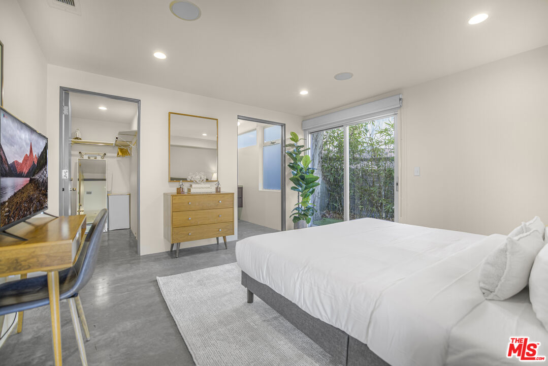 9892 Beverly Grove Drive Beverly Hills, CA 90210 - Photo 31 of 39 a bedroom with a bed and large windows