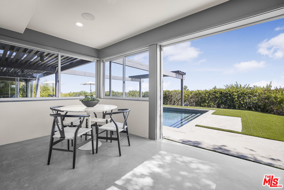 9892 Beverly Grove Drive Beverly Hills, CA 90210 - Photo 4 of 39 a dinning area with a table and chairs