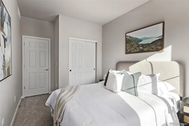 a bedroom with a bed and a painting on the wall