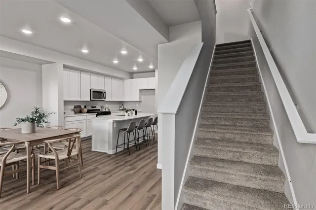 a kitchen with white cabinets and chairs