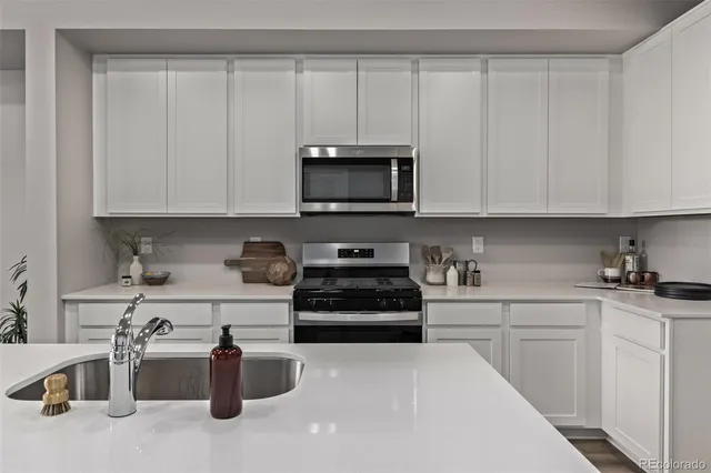 a kitchen with a stove and white cabinets