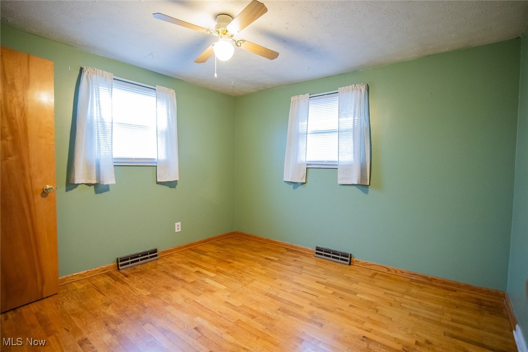 91 Mike Street Washington, WV 26181 - Photo 19 of 42 Unfurnished room with hardwood / wood-style floors, plenty of natural light, a textured ceiling, and ceiling fan