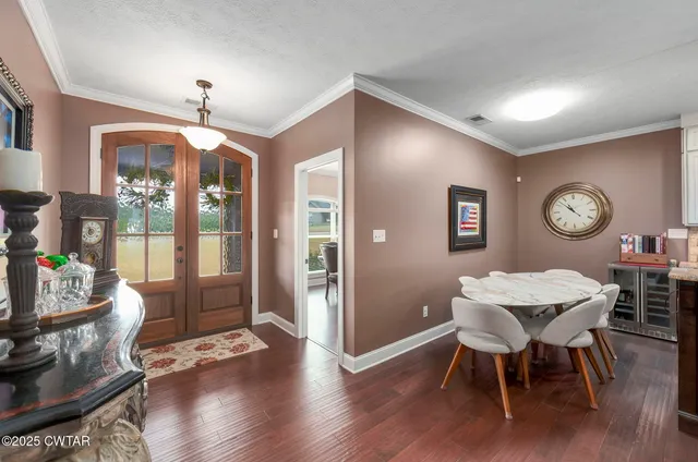 a living room with furniture kitchen view and a large window