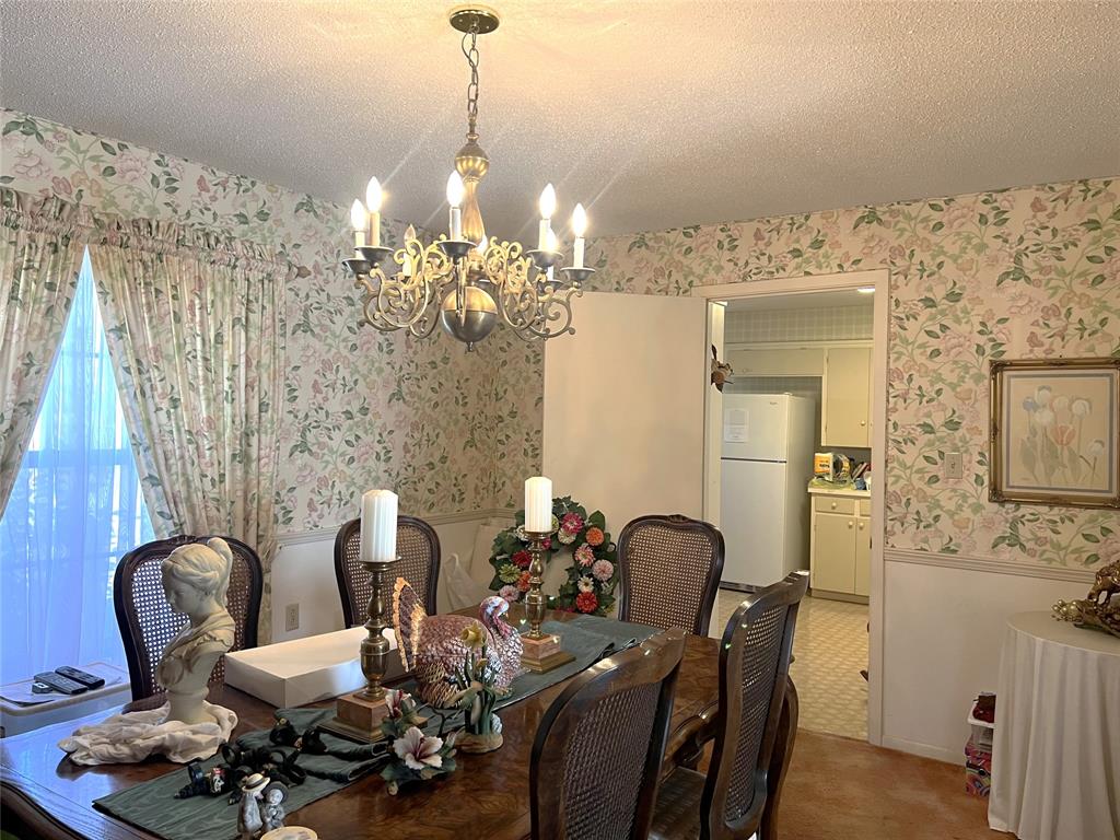 316 East Spring Street Henrietta, TX 76365 - Photo 16 of 28 a view of a dining room with furniture and chandelier