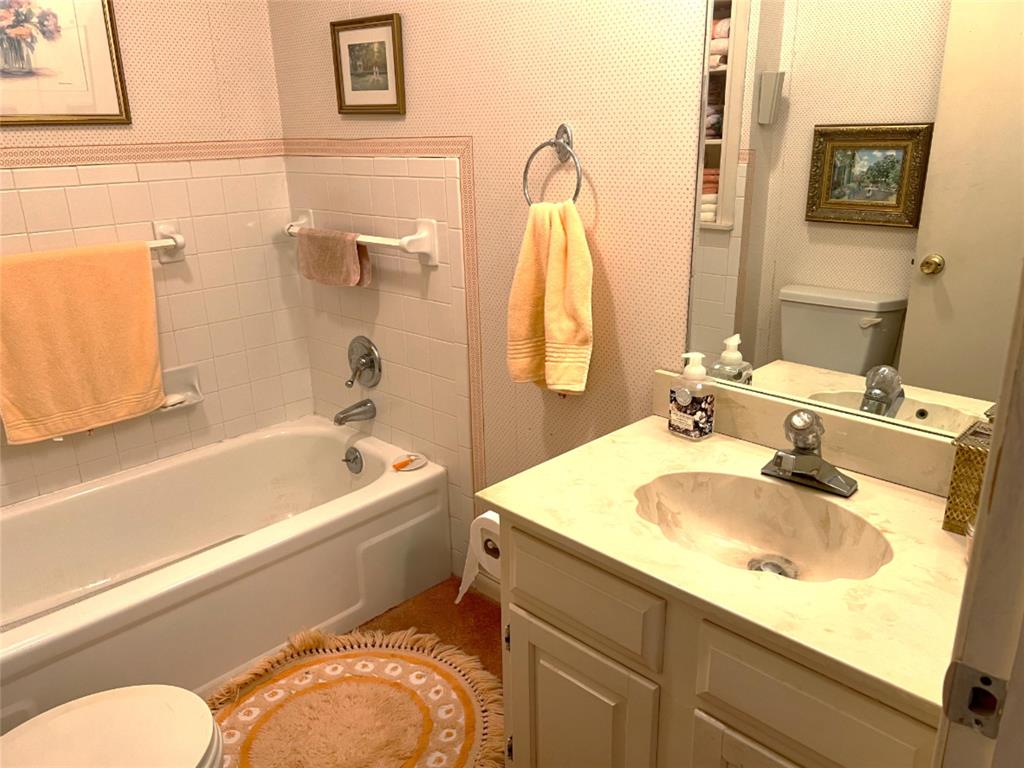 316 East Spring Street Henrietta, TX 76365 - Photo 25 of 28 a bathroom with a sink and a mirror