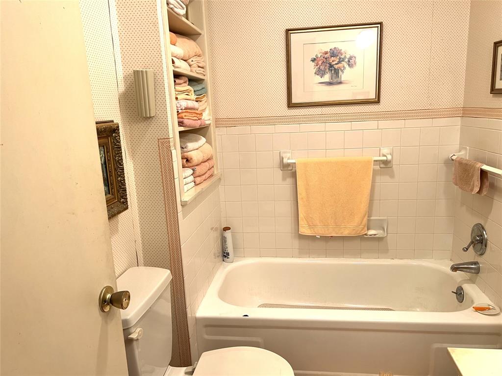 316 East Spring Street Henrietta, TX 76365 - Photo 26 of 28 a bathroom with a bathtub and a shower