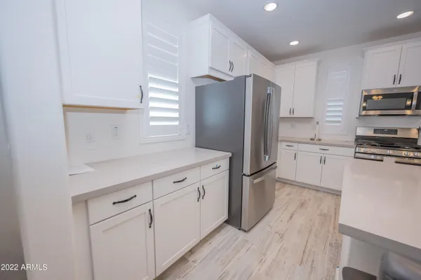 a kitchen with white cabinets and stainless steel appliances