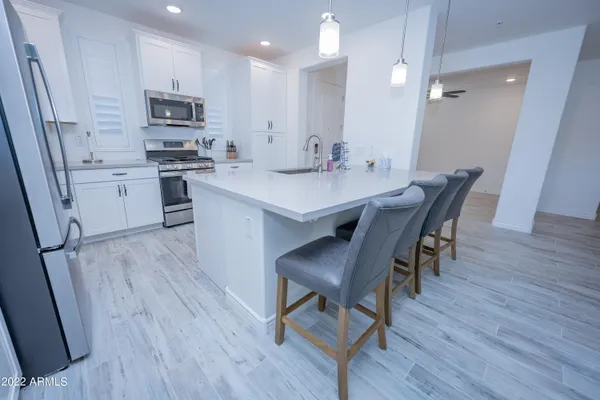 a kitchen with a sink a microwave a stove and cabinets