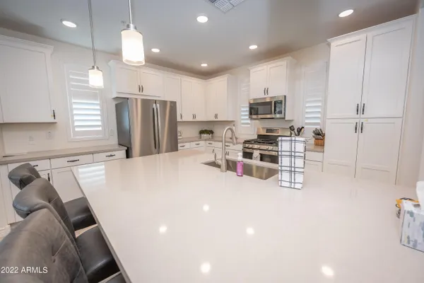 a kitchen with stainless steel appliances a refrigerator and a stove top oven