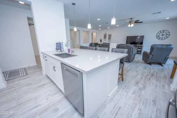 a large kitchen with stainless steel appliances a lot of counter space and a wooden floor