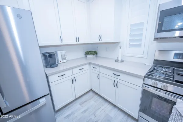 a kitchen with white cabinets and white appliances