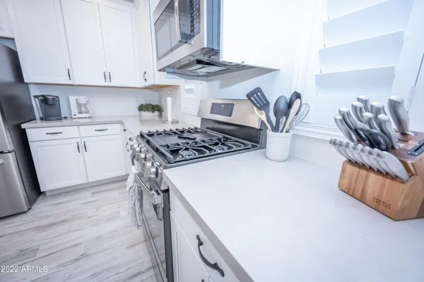 a kitchen with stainless steel appliances granite countertop a sink stove and cabinets