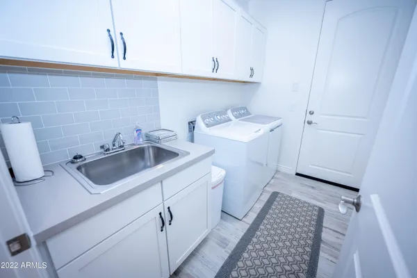 a utility room with sink dryer and washer