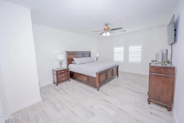 a spacious bedroom with a bed and a dresser