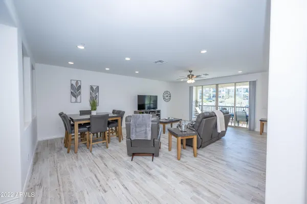 a living room with furniture a large window and stainless steel appliances