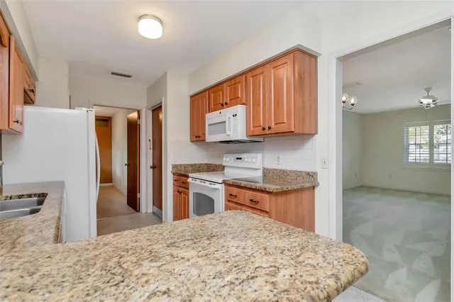 a kitchen with stainless steel appliances granite countertop a refrigerator a stove top oven a sink and dishwasher