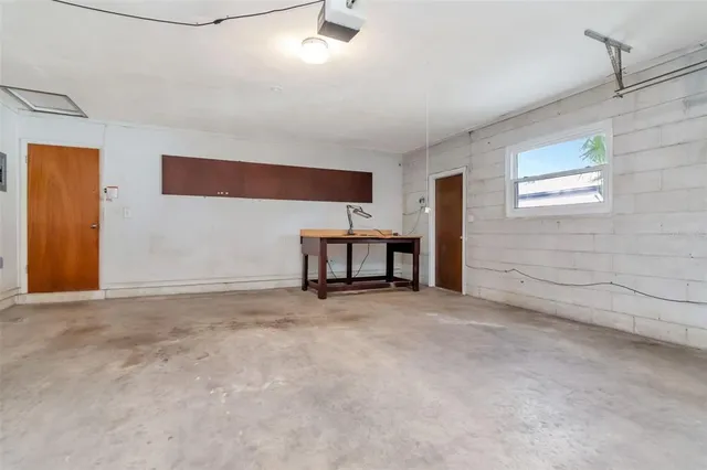 a view of an empty room with furniture and window