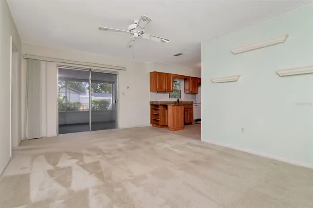 a view of a room with cabinet a flat screen tv and kitchen view