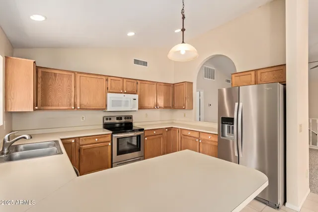a kitchen with stainless steel appliances a stove refrigerator sink and microwave
