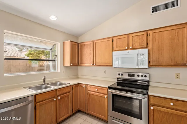 a kitchen with a sink stove top oven and cabinets