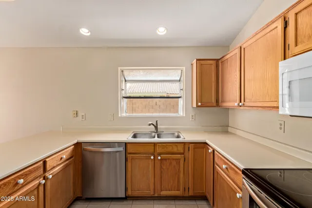 a kitchen with granite countertop cabinets sink and window