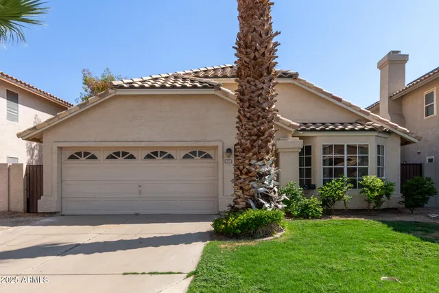 a view of a house with a yard and potted plants
