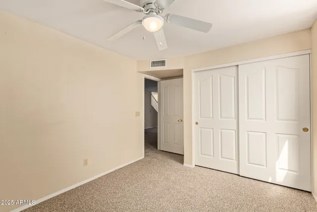 an empty room with a ceiling fan and a window