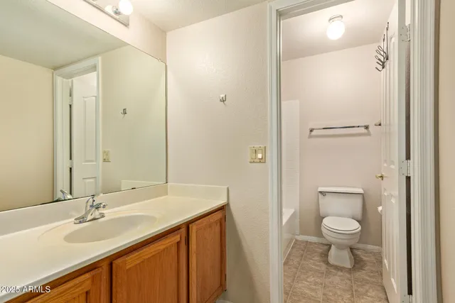 a bathroom with a granite countertop sink a toilet and a shower