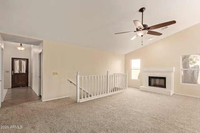 a view of a livingroom with a ceiling fan and fireplace
