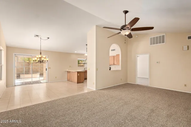 a view of a big room with a chandelier fan and windows