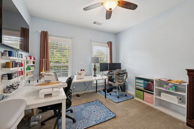 a view of a workspace with furniture and a window